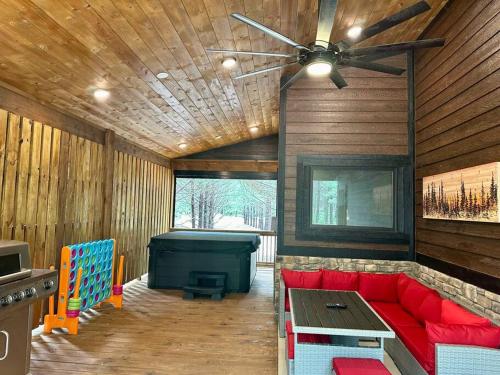 a living room with a red couch and a pool table at The Whiskey Trip! Family Getaway in Broken Bow