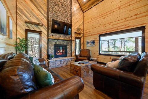 a living room with leather furniture and a fireplace at The Whiskey Trip! Family Getaway in Broken Bow