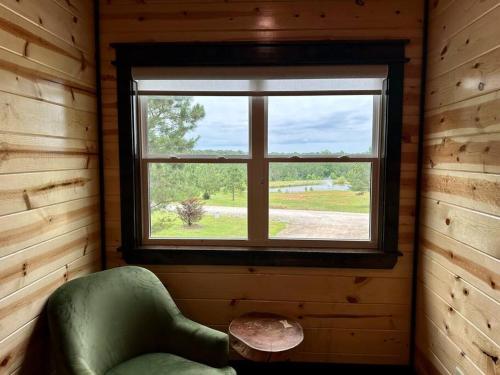 a room with a green chair and a window at The Whiskey Trip! Family Getaway in Broken Bow
