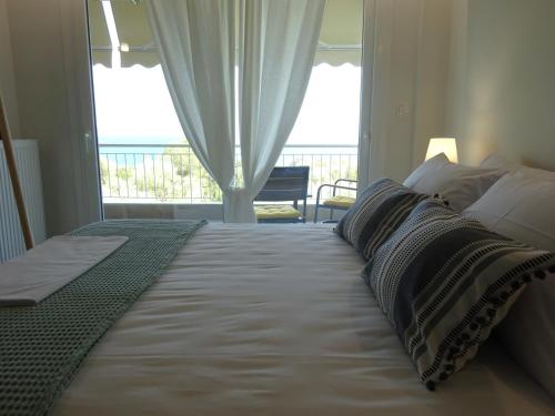 a bedroom with a large bed with a view of the ocean at Palio Seaside Escape in Kavala
