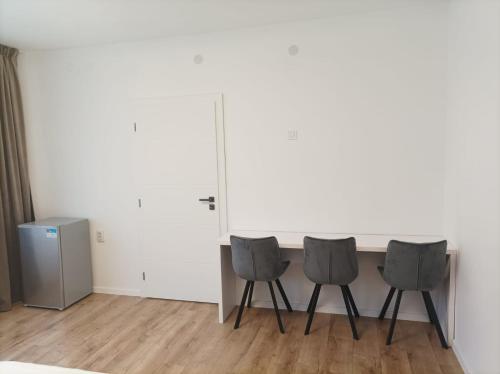 three chairs in a room with a white wall at Casa Taramului in Turda