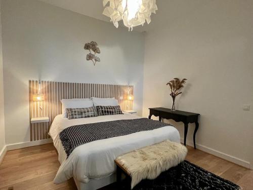 une chambre avec un lit, une table et un lustre dans l'établissement Havre de confort Bordeaux Chartrons - Cité du vin, à Bordeaux