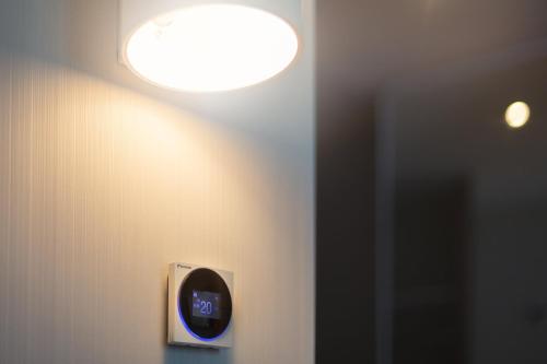 a light on a wall with a clock on it at Holiday Inn Express - Erlangen by IHG in Erlangen