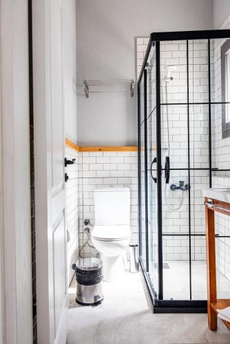 a bathroom with a toilet and a glass door at Akkum Beach Otel in Seferihisar