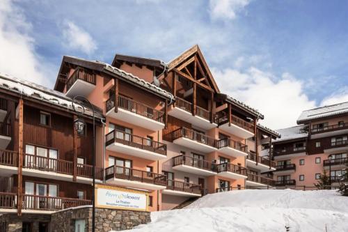 un bâtiment avec de la neige devant lui dans l'établissement Résidence Le Thabor - maeva Home - Appartement 3 pièces 8 personnes - Sélection MAE-5731, à Le Désert