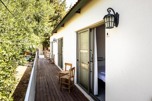 a porch with a glass door and chairs on a house at Akkum Beach Otel in Seferihisar