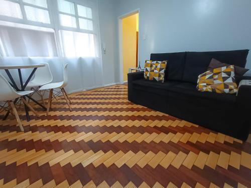 a living room with a couch and a table at Na Cidade Baixa, perto de tudo - UFRGS, Santa Casa, Parques, Orla in Porto Alegre