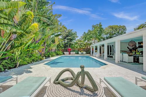 a pool with a statue in front of a house at New! Waterfront Heated Pool, Fishing Pier, Designer Touches, 2mi to Beach in Fort Lauderdale