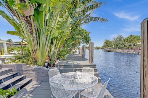 a white cat sitting on a table next to the water at New! Waterfront Heated Pool, Fishing Pier, Designer Touches, 2mi to Beach in Fort Lauderdale
