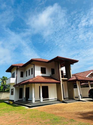 a white house with a red roof at Royal Villa in Marawila