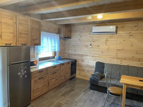 a kitchen with a refrigerator and a couch in a room at Sosnowy Domek Parter Zator Graboszyce in Graboszyce