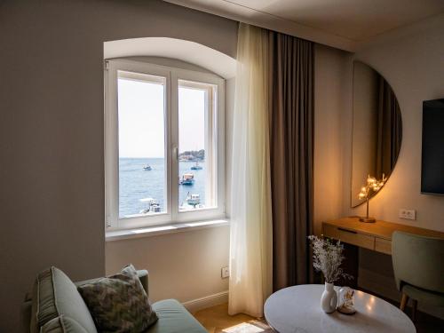 a living room with a window with a view of the ocean at Topaz Rooms in Hvar