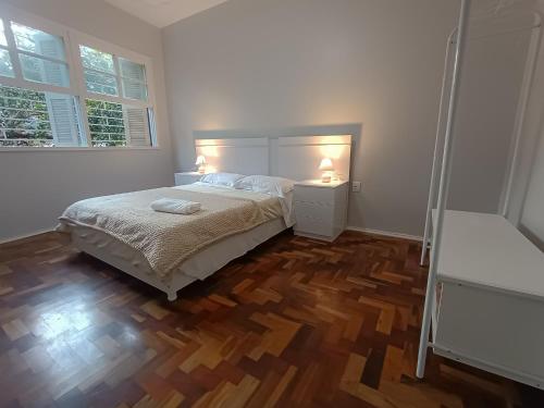 a bedroom with a bed and a wooden floor at Na Cidade Baixa, perto de tudo - UFRGS, Santa Casa, Parques, Orla in Porto Alegre