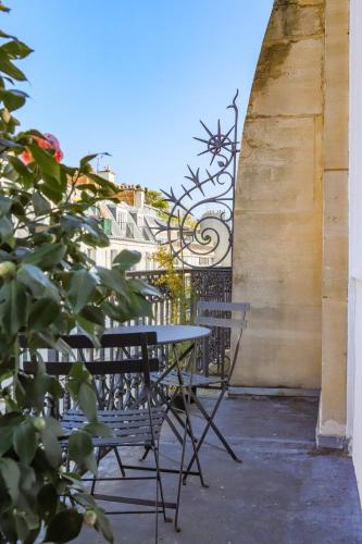 d'une table et de chaises sur un balcon avec une clôture. dans l'établissement Parc Monceau Artist's Atelier, à Paris