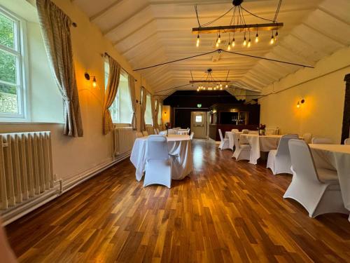 a banquet hall with white tables and white chairs at The George Inn at Tideswell in Tideswell