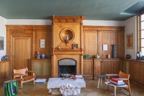 un salon avec une cheminée et une table dans l'établissement Parc Monceau Artist's Atelier, à Paris