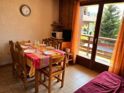 une salle à manger avec une table, des chaises et une horloge dans l'établissement Résidence Coupe De Cristal - Coupe de Cristal A6 MAE-6544, à Saint-Gervais-les-Bains