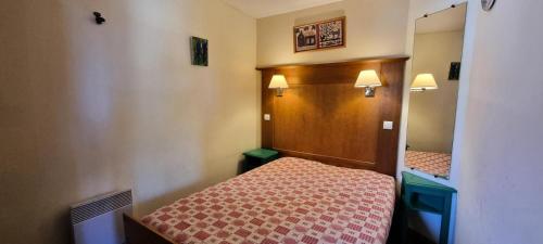 une petite chambre avec un lit et un miroir dans l'établissement Résidence Mont Soleil B - Appartement 5 personnes - Plagne Soleil MAE-4614, à La Plagne Tarentaise