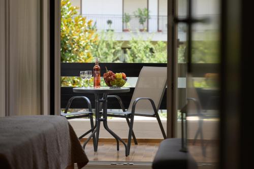 a table with a bowl of fruit and a bottle of wine at City Center Apartment in Ioannina