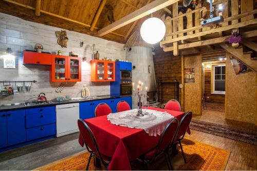 a kitchen with a table with a red table cloth at Rymanowskie Zamczysko in Rymanów-Zdrój