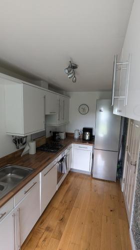 a kitchen with white cabinets and a refrigerator at Sleeps up to 8 guests - Modern townhouse near Newcastle in Willington Quay