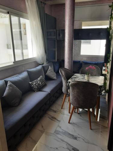 a living room with a blue couch and a table at hermoso apartamento con piscina en marjane in Tetouan