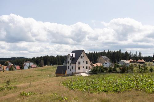 a house in the middle of a field at Vila Oaza mira Golija in Golija