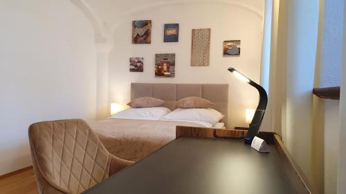 a bedroom with a bed and a desk with a lamp at Ferienwohnung mit Alpenblick - Kufstein Suite am Simssee in Stephanskirchen