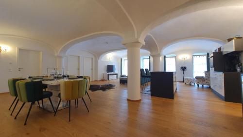 a dining room and living room with a table and chairs at Ferienwohnung mit Alpenblick - Kufstein Suite am Simssee in Stephanskirchen