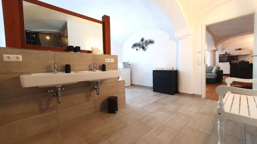a bathroom with two sinks and a mirror at Ferienwohnung mit Alpenblick - Kufstein Suite am Simssee in Stephanskirchen