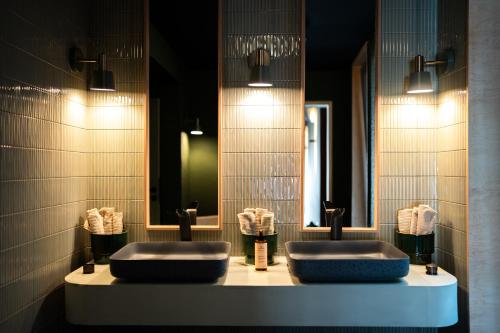 two sinks in a bathroom with two mirrors at L'Olivier in Mons
