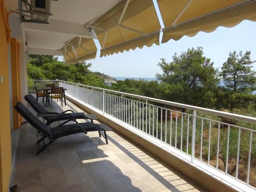 a balcony with chairs and a view of the ocean at Palio Seaside Escape in Kavala