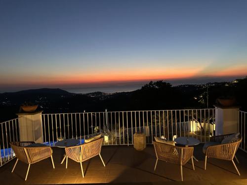 a balcony with tables and chairs and a sunset at Palazzo Gargano in Prignano Cilento