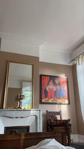 un salon avec une cheminée et un miroir dans l'établissement La Villa Russe, à Gurs