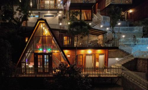 a house with a staircase leading up to it at night at Koro Treehouse Resort Luxury Wooden Cottages and Villas with Private Pool in Kasauli