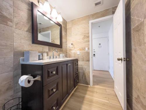 a bathroom with a sink and a mirror at Ocean Drive apartment w Balcony Walk to the Beach in Miami Beach