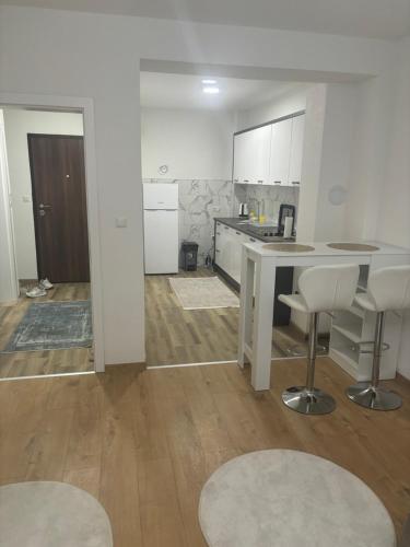 a kitchen with a table and chairs in a room at Apartman Aura in Travnik