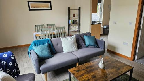 a living room with a couch and a table at The Apartment at Brook House in Llanberis