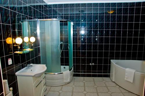 a bathroom with a shower and a toilet and a tub at Hotel Merkuriy in Lviv