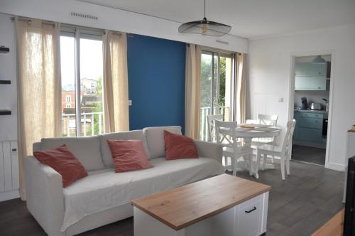 un salon avec un canapé et une table dans l'établissement Le 64 Appartement cosy et calme en Centre-ville, à Charleville-Mézières