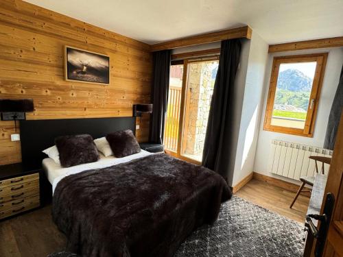 une chambre avec un grand lit dans une pièce aux murs en bois dans l'établissement Résidence Le Centaure - 4 Pièces pour 8 Personnes 571, à Aime La Plagne