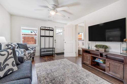 a living room with a couch and a flat screen tv at Baby Blue Cottage Downtown Hot Tub BBQ Fire Pit in Colorado Springs