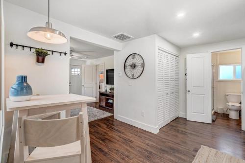 a kitchen with a table and a clock on the wall at Baby Blue Cottage Downtown Hot Tub BBQ Fire Pit in Colorado Springs