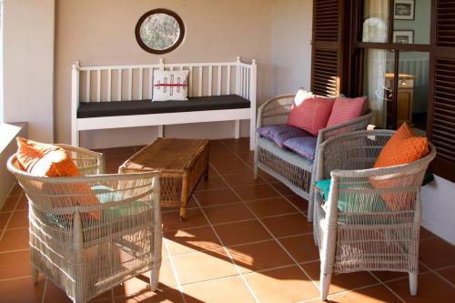 a living room with chairs and a crib and a table at Trengwainton Cottage in Hogsback