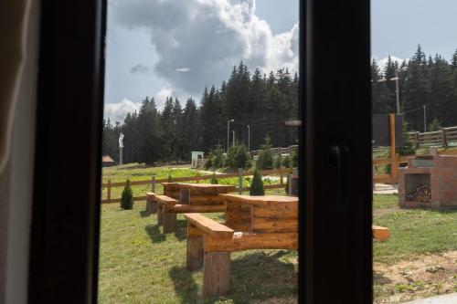 a view of a group of picnic tables through a window at Vila Oaza mira Golija in Golija