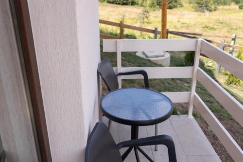 a table and chairs sitting on a porch at Vila Oaza mira Golija in Golija
