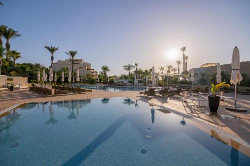 a large swimming pool in a resort with palm trees at Quinta da Boa Nova - Cheerful and spacious 2-bedroom duplex in Estômbar