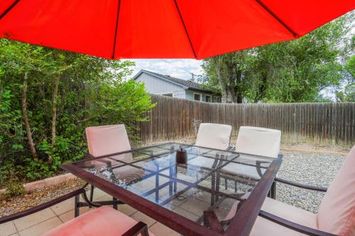 a table with chairs and a red umbrella on a patio at Blackstone Trails Downtown w BBQ & Fire Pit in Colorado Springs