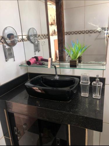 a bathroom with a black sink and a mirror at Olinda Home in Olinda