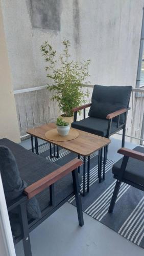 a table and chairs on a balcony with a plant at Apartment Feral in Neum